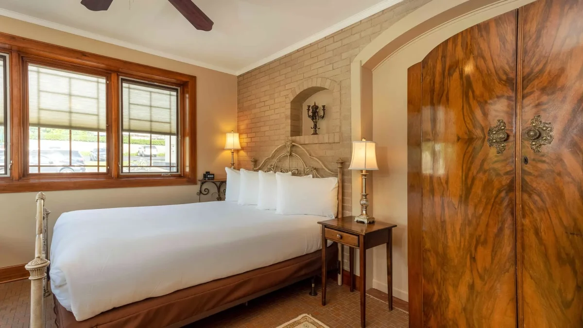 A hotel bedroom with a bed and closet.