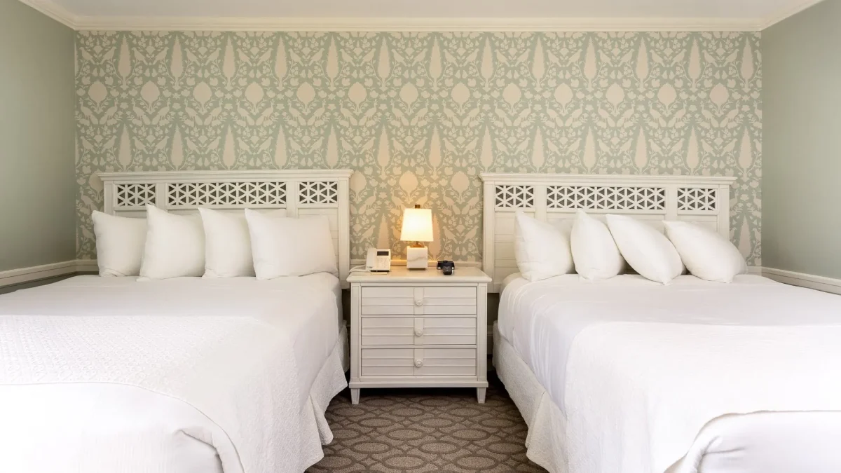 Two beds side by side in a hotel room.