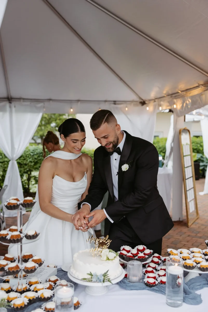 Bride and groom cutting cake at wedding reception.